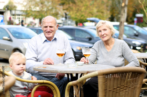 Active grandparents with granddaughter in outdoors cafe