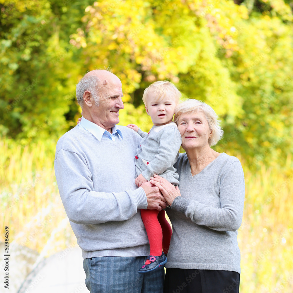 Happy grandparents with little baby granddaughter in the park Happy grandparents with little baby granddaughter in the park