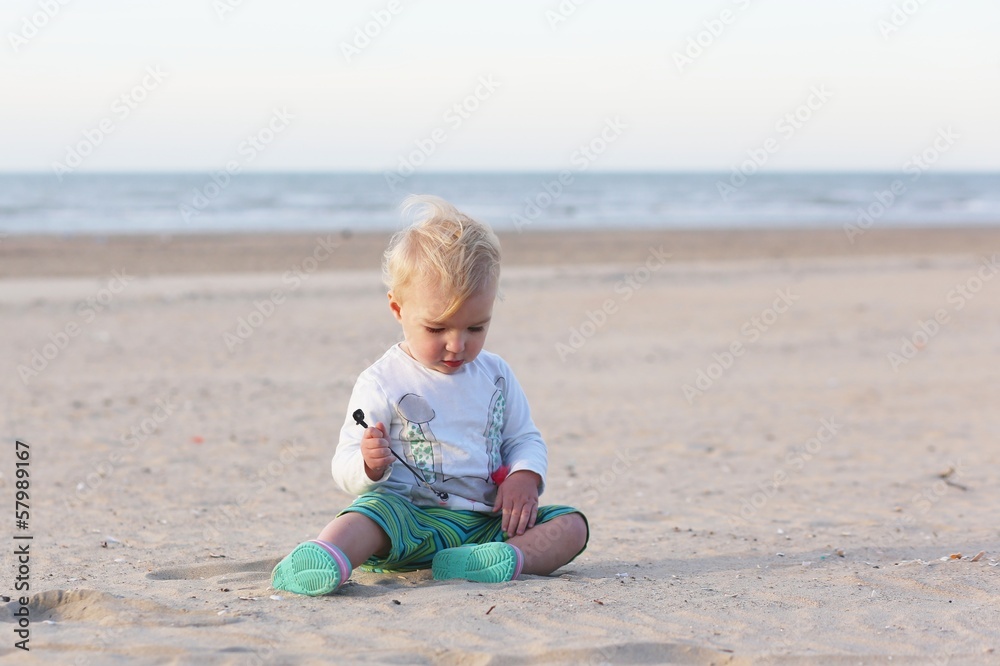 Little sweet baby girl plays with sand on the beach Little sweet baby girl plays with sand on the beach
