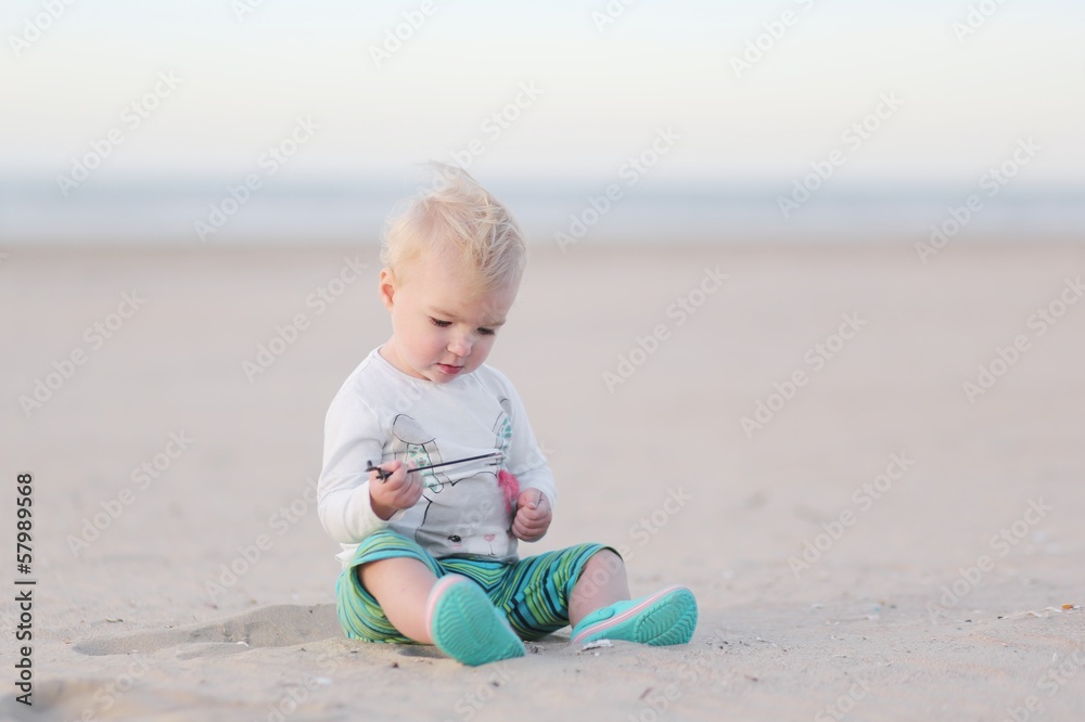 Little cute baby girl plays with sand on the beach Little cute baby girl plays with sand on the beach