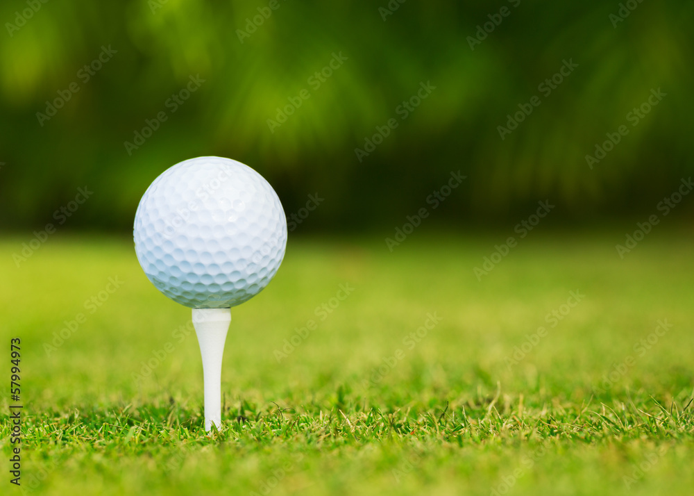 Close up view of golf ball on tee on golf course Close up view of golf ball on tee on golf course