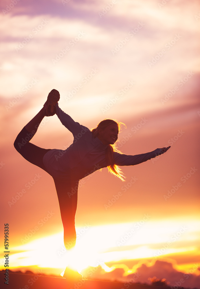 Silhouette of a Beautiful Woman Practicing Yoga at Sunset