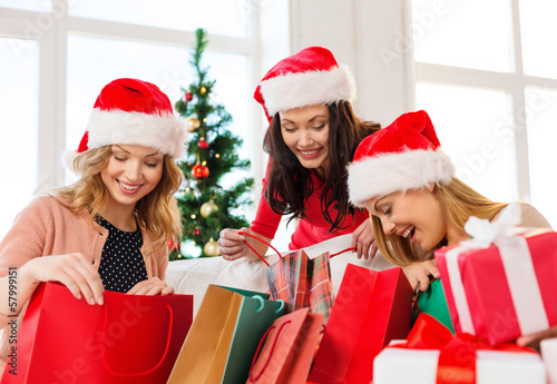 women in santa helper hats with shopping bags