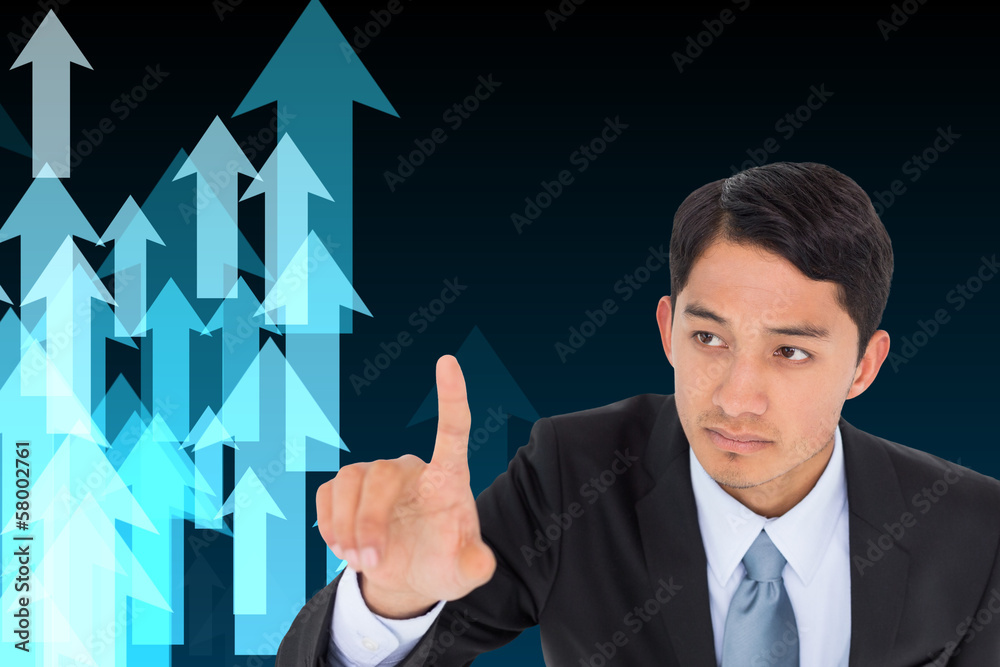 Composite image of unsmiling asian businessman pointing Composite image of unsmiling asian businessman pointing