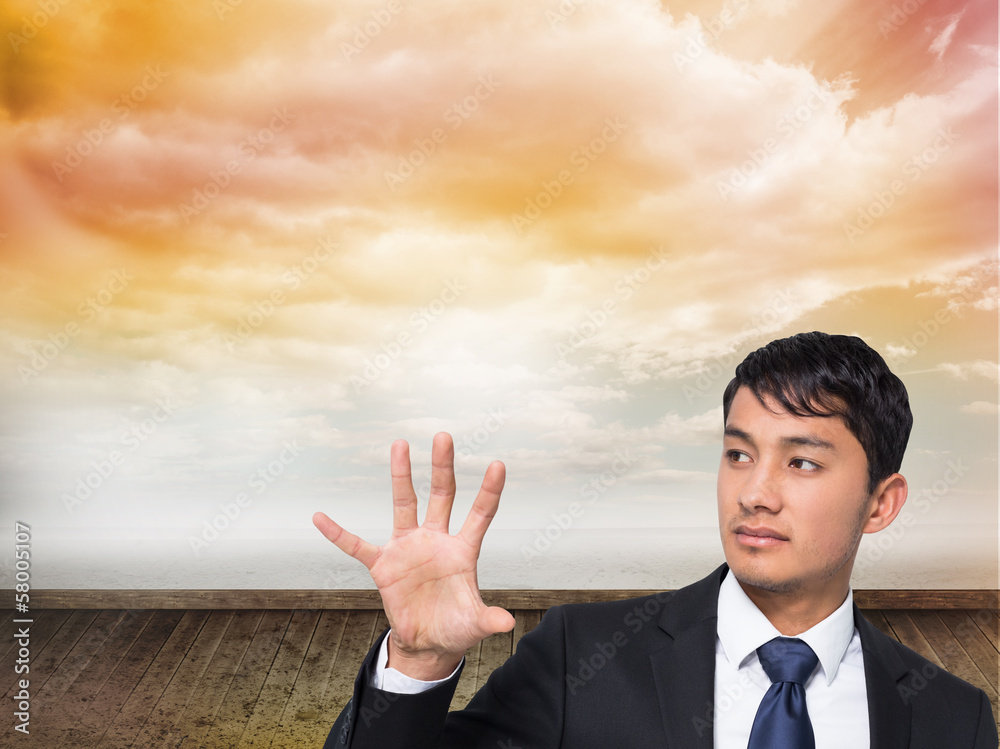Composite image of unsmiling businessman holding and pointing Composite image of unsmiling businessman holding and pointing
