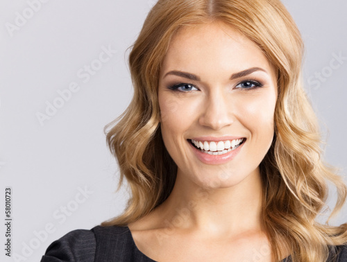 Young cheerful smiling woman, on gray