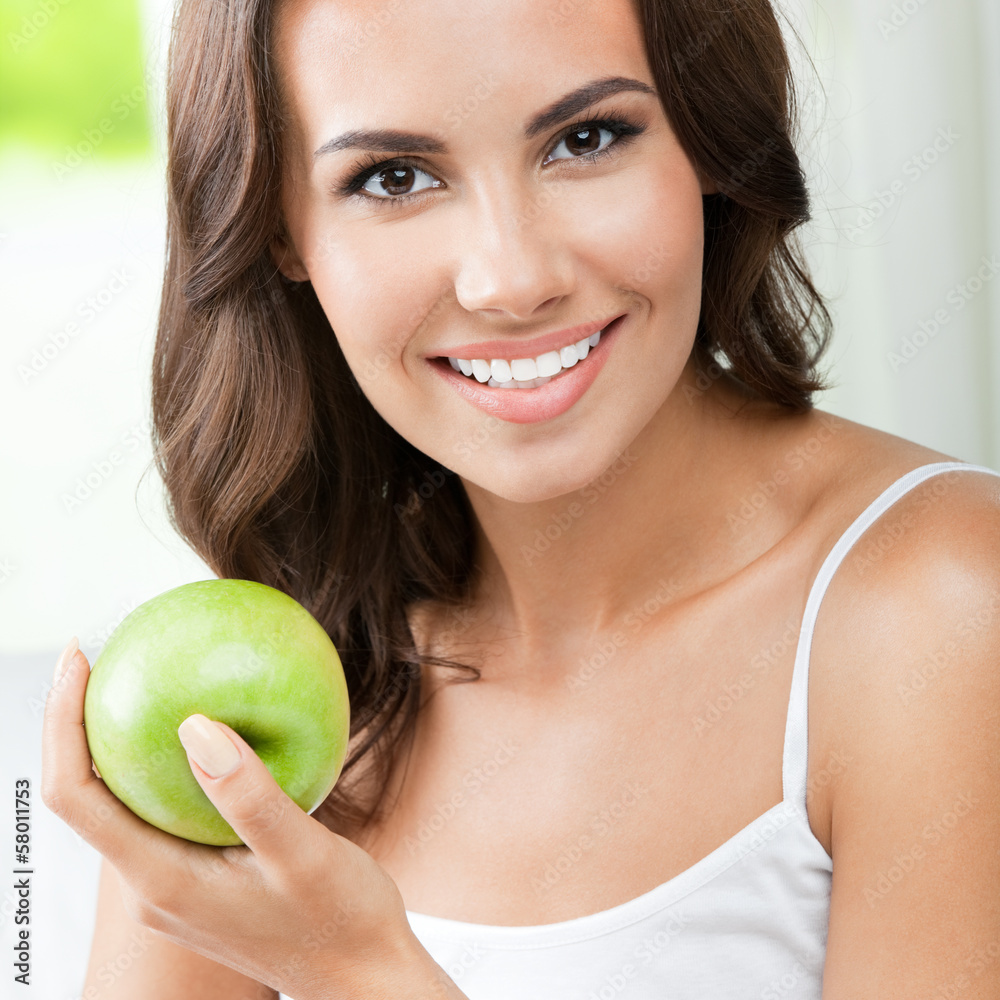 Young happy smiling woman with apple, indoors Young happy smiling woman with apple, indoors