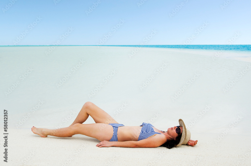 Young woman sunbathing on Aitutaki Lagoon Cook Islands Young woman sunbathing on Aitutaki Lagoon Cook Islands