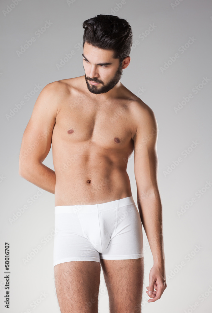 sexy handsome naked man in underwear posing in the studio