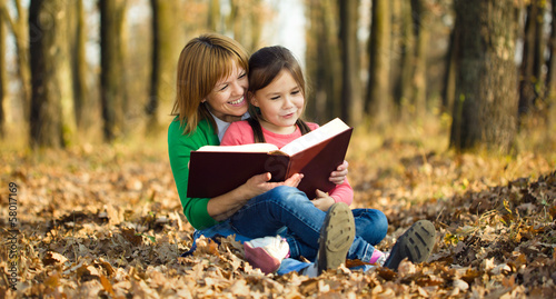 Mother is reading book with her daughter