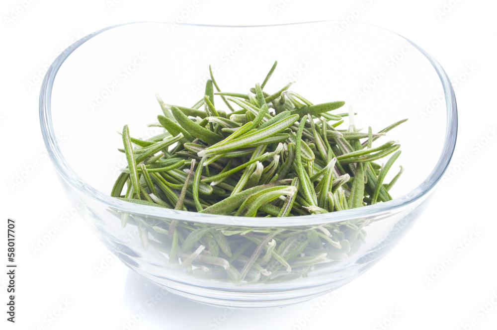 Fresh rosemary leaves in a glass bowl on white background Fresh rosemary leaves in a glass bowl on white background