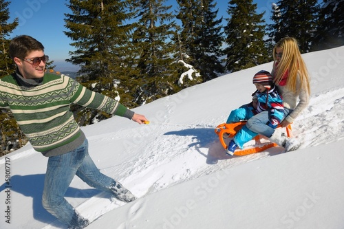 family having fun on fresh snow at winter vacation