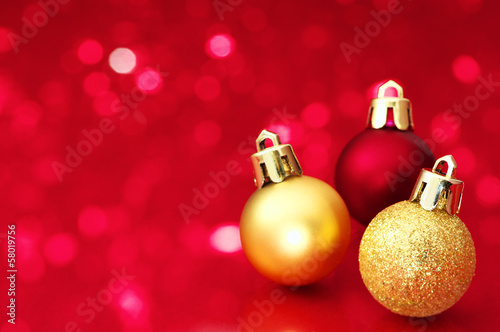 Christmas balls on red defocused lights background.