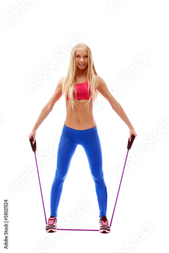 Cute aerobics instructor posing with skipping rope