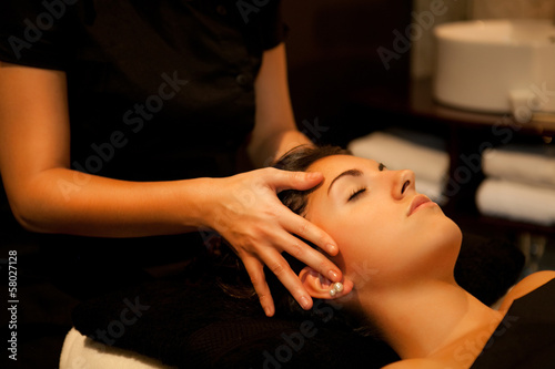 Woman getting a face massage in a spa.