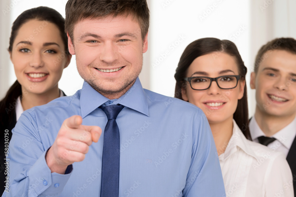 Smiling successful business man pointing with finger on camera. Smiling successful business man pointing with finger on camera.