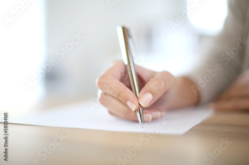 Closeup of woman's hand writing on paper