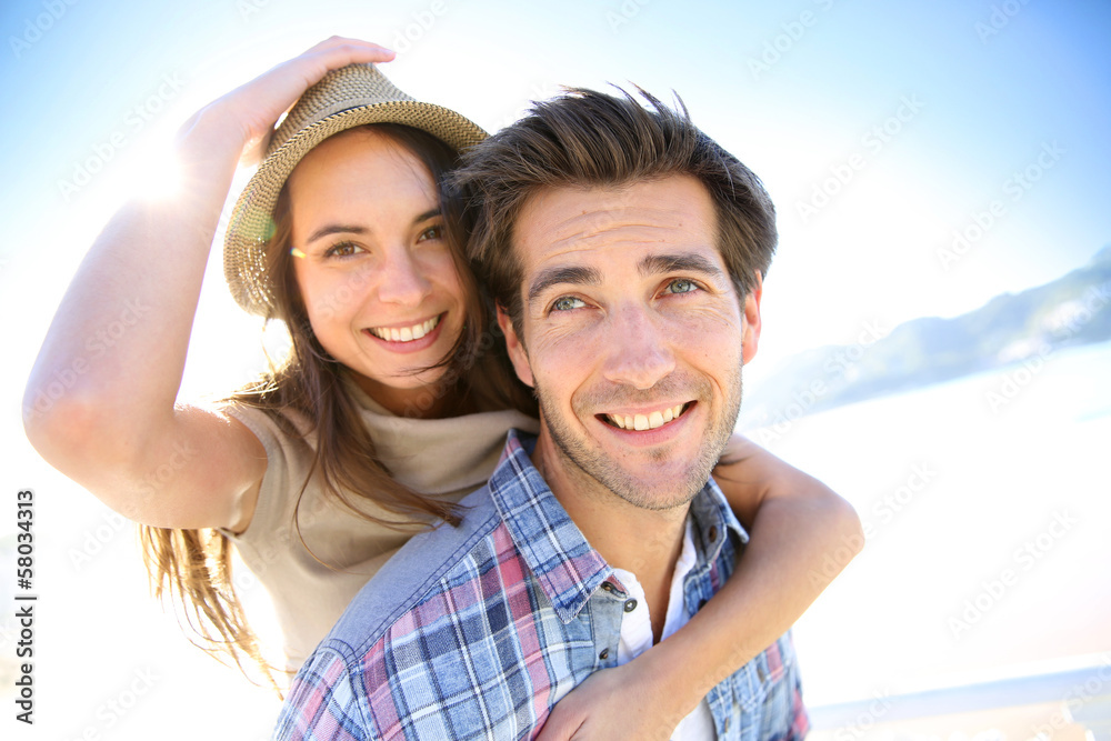 Man giving piggyback ride to girlfriend at the beach Man giving piggyback ride to girlfriend at the beach