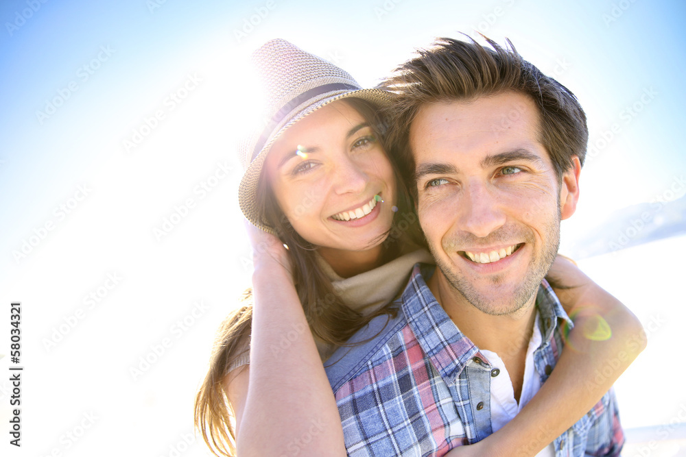 Man giving piggyback ride to girlfriend at the beach Man giving piggyback ride to girlfriend at the beach