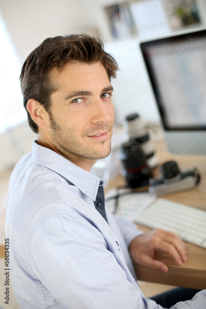 Fototapeta premium Photographer in office working on desktop computer