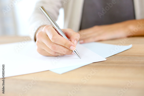 Closeup of woman's hand writing on paper photo