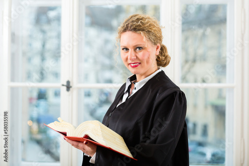 Anwältin in Kanzlei mit Gesetzbuch photo