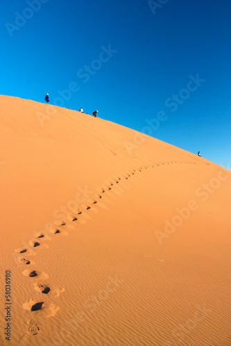 People walking on dune in Erg Chigaga leaving footprints