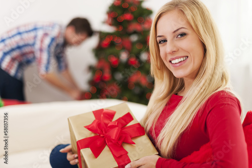 Smiling blonde woman sitting on the sofa in christmas time