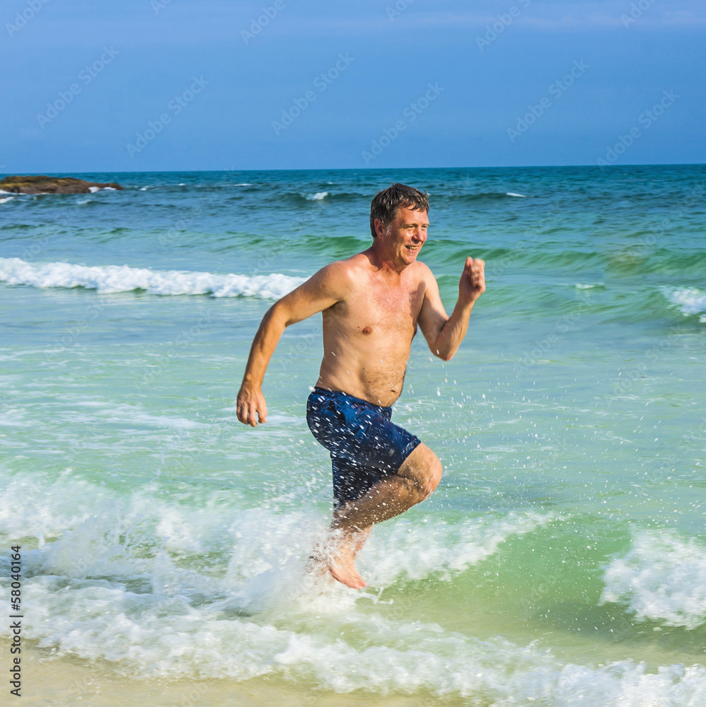 man runs along the beautiful beach