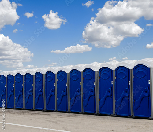 A row of blue portable toilets photo