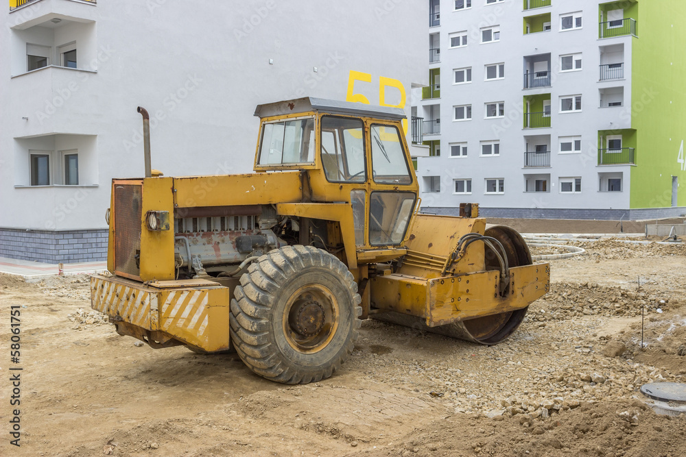 Yellow road roller in the new residential area Yellow road roller in the new residential area