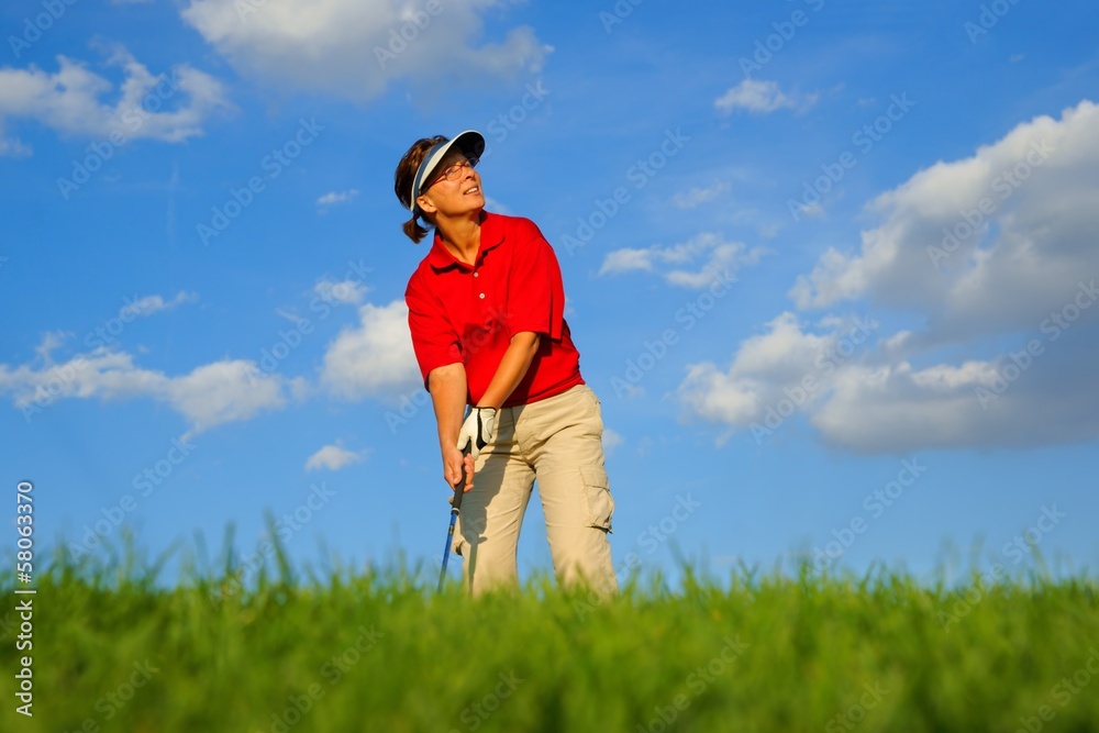 Golf, woman golfer observing the flight of the ball Golf, woman golfer observing the flight of the ball