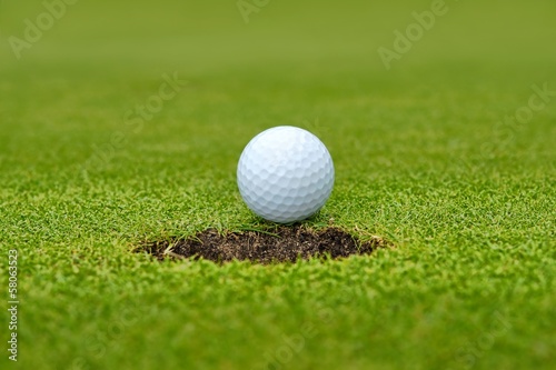 Golf, ball lying on the green next to hole