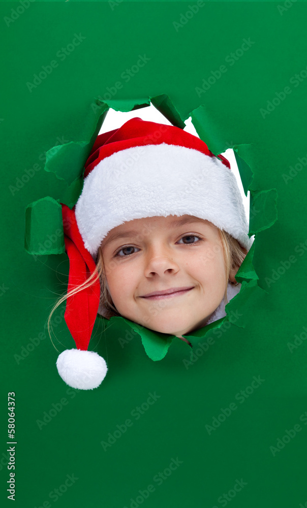 Christmas girl looking through hole in paper Christmas girl looking through hole in paper