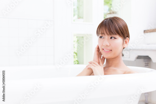 young asian woman relaxing in the bathroom