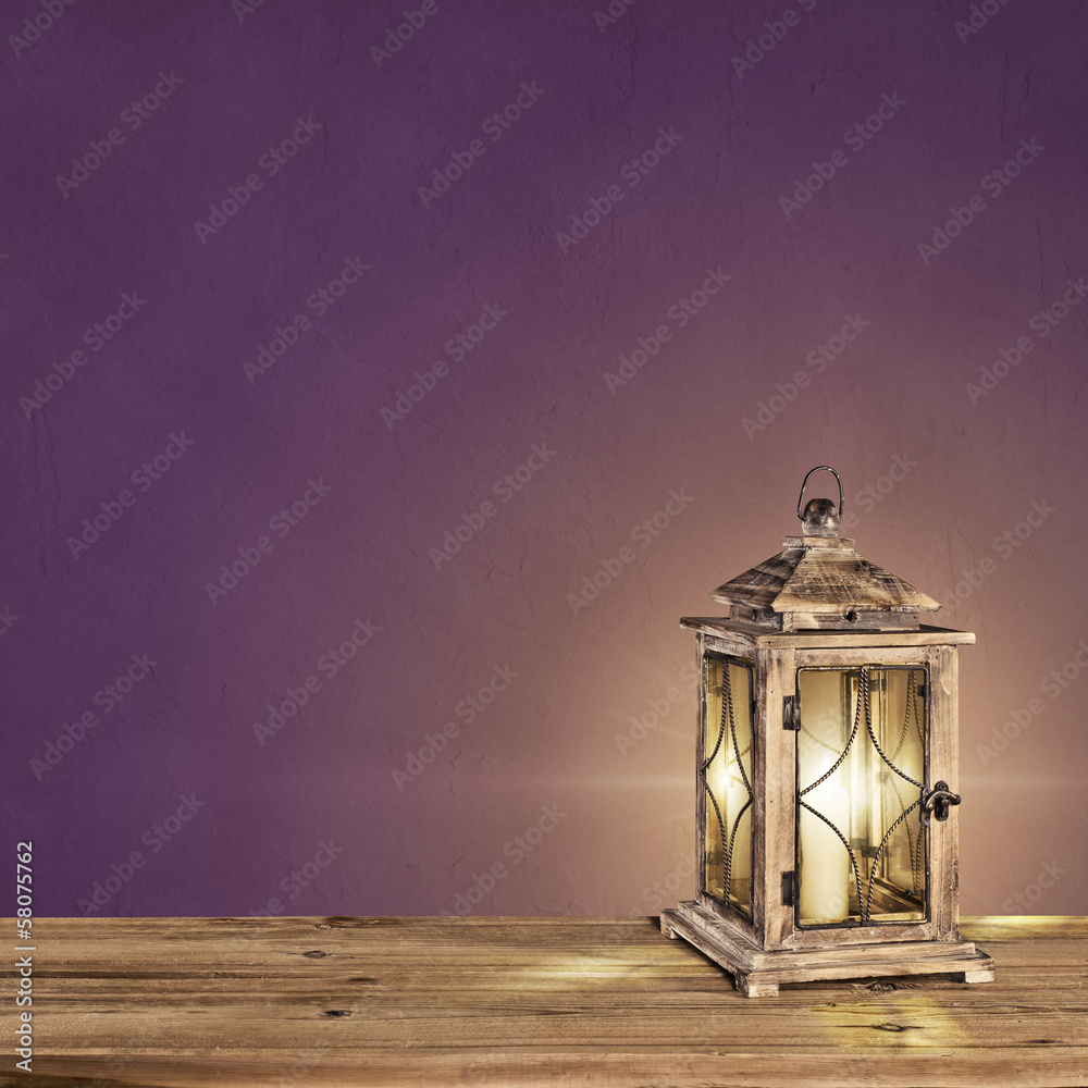 vintage lantern with a candle on a violet vintage background