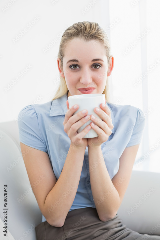 Gorgeous calm businesswoman holding a cup smelling a cup Gorgeous calm businesswoman holding a cup smelling a cup