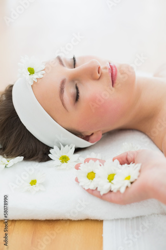Beautiful woman lying on massage table in beauty salon