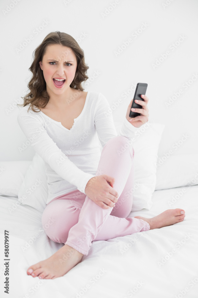 Cheerful woman with mobile phone in bed Cheerful woman with mobile phone in bed