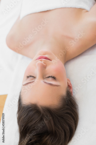 Brunette on massage table with eyes closed