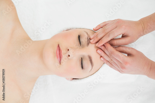 Hands massaging a beautiful woman's forehead