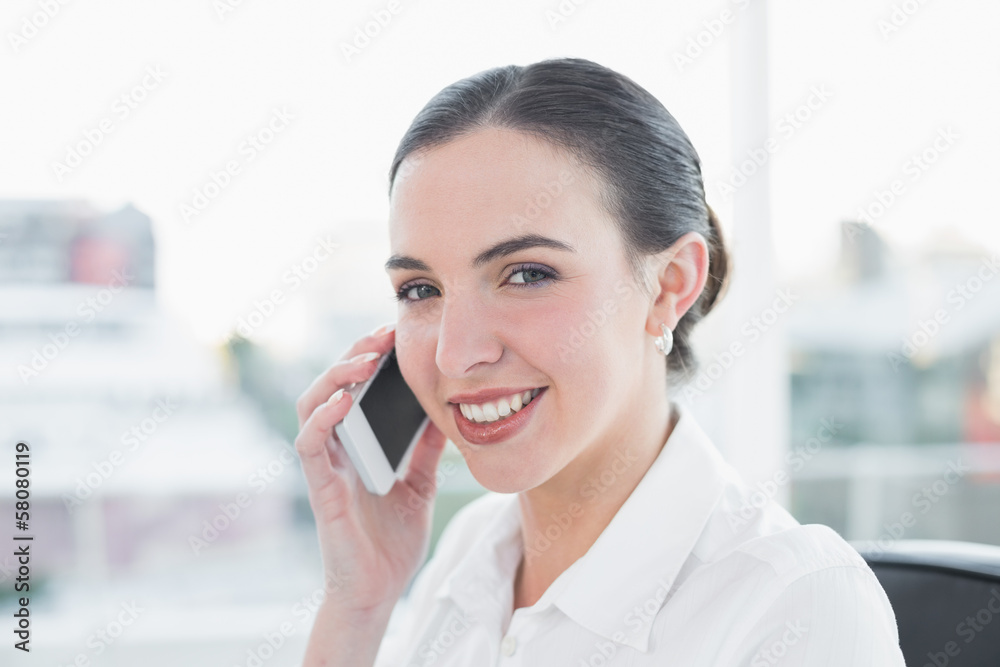 Smiling businesswoman using mobile phone in office Smiling businesswoman using mobile phone in office