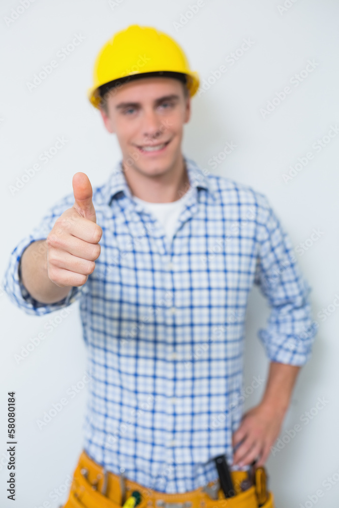 Portrait of a handyman in yellow hard hat gesturing thumbs up Portrait of a handyman in yellow hard hat gesturing thumbs up