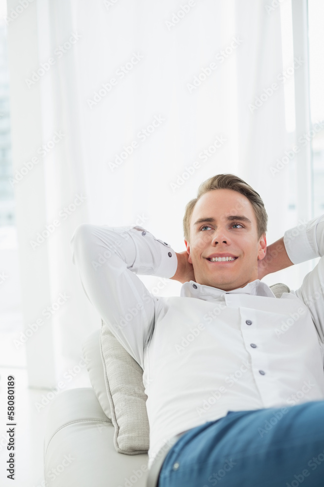 Smiling relaxed young man lying on sofa Smiling relaxed young man lying on sofa