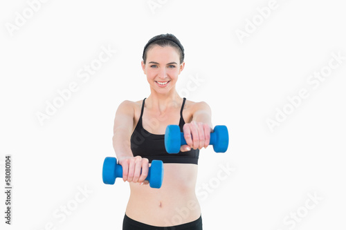 Portrait of a smiling young woman with dumbbells