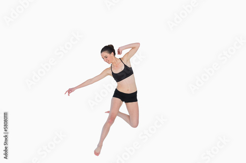 Fototapeta Naklejka Na Ścianę i Meble -  Full length of a sporty young woman jumping
