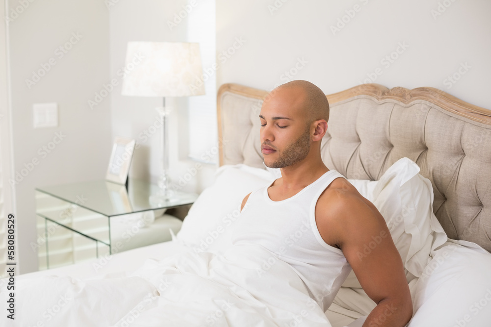 Relaxed young bald man with eyes closed in bed Relaxed young bald man with eyes closed in bed
