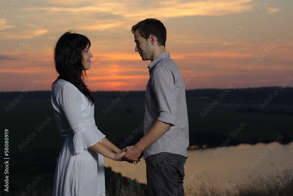 Couple sweethearts at sunset and lake