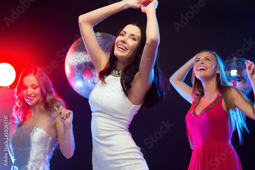 three smiling women dancing in the club