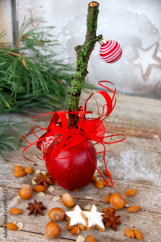 roter Apfel mit Zimtsternen und Nüssen photo